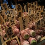 肉巻き野菜串がたくさん木箱に入って並べられている画像